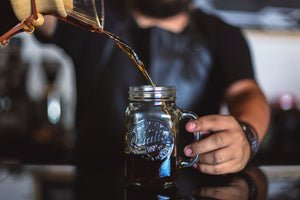 A specialty coffee class, training in Chicago and Chicagoland. A barista pouring a cold brew coffee into a mason jar.