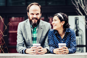 A happy engaged couple enjoying specialty coffee by the river downtown Chicago.