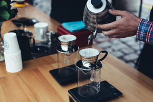 Making Kalita Wave specialty coffee drinks. Pouring from a goose-neck-style kettle. Using scales and precise recipes.